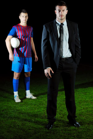 soccer sport manager in business suit coach and football player on stadium with green grass and white ball